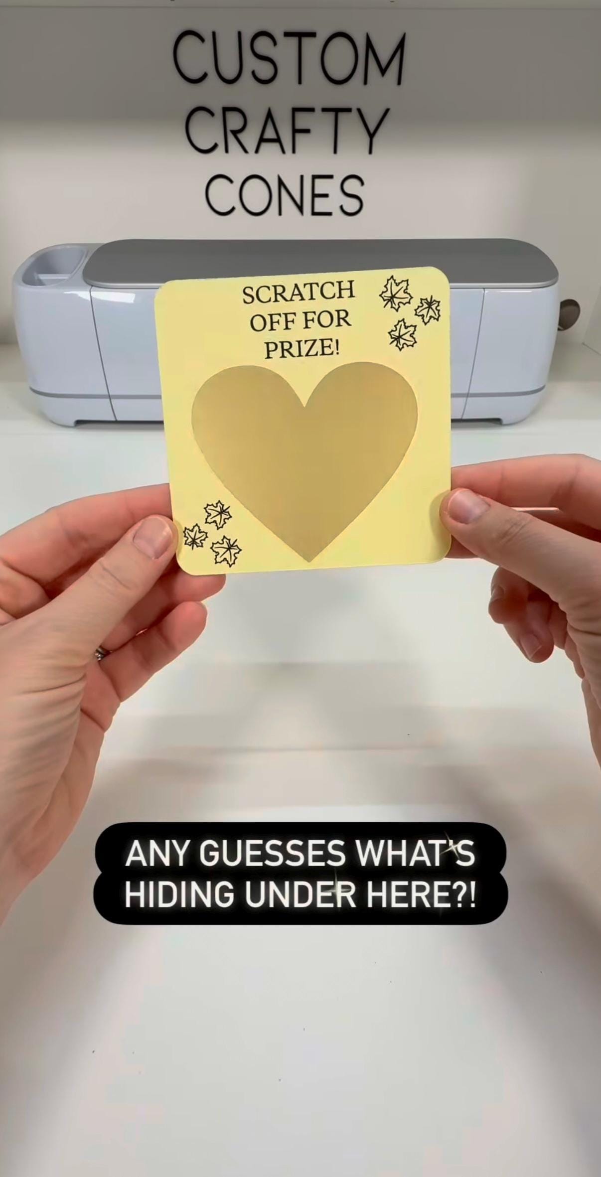 A gold-heart scratch-off prize card held at Laura's worktable